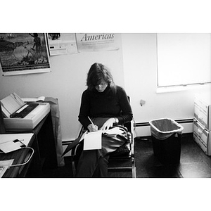 Woman sitting in her office with her paperwork on her lap.