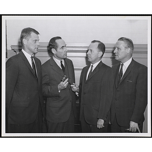 Four board members standing in front of a wall