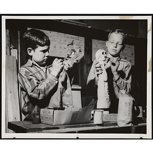 Two boys working on projects for their arts and crafts class at the Boys' Clubs of Boston