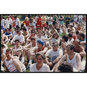 A group of runners sit on the grass during the Bunker Hill Road Race