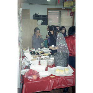 Woman takes some food at a buffet table during a celebration of the Chinese New Year, hosted by the Chinese Progressive Association