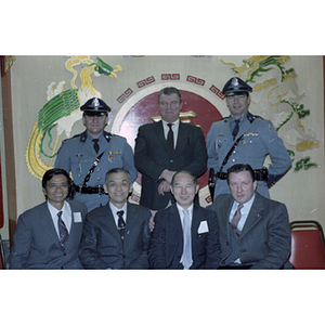 Henry Wong poses for a photograph with members of the Guangdong Province delegation and two officers in uniform