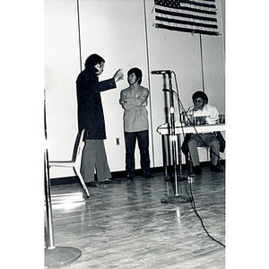 Three men perform a theatrical sketch onstage at the Josiah Quincy School about the normalization of U.S. and China relations in the setting of a Chinese restaurant