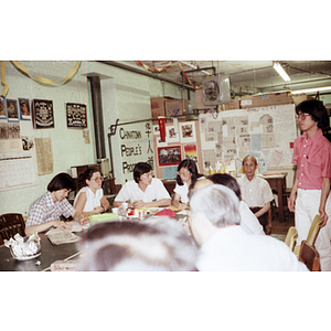 Chinese Progressive Association members converse around a table during a tutoring class dinner