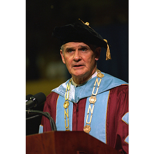 President John Curry speaking from the podium at commencement