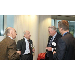 Neal Finnegan speaks with three other men at the Veterans Memorial dinner