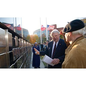 Neal Finnegan gestures toward the Veterans Memorial at the dedication ceremony