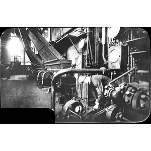 A student oils a Stoker Motor at the Boston Woven Hose and Rubber Company