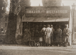 Soldiers in front of a small free standing storefront with a sign reading "Bazar Militaires"