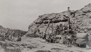 Soldiers sitting outside a large bunker with makeshift kitchen, entrance to Fort Douaumont
