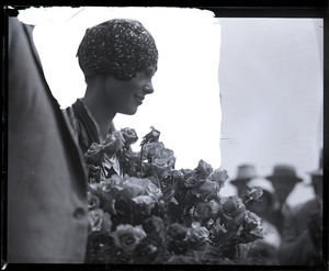 Amelia Earhart reception: close-up of Earhart with bouquet of flowers