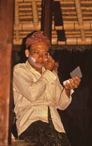 Balinese temple dancer applying his stage makeup