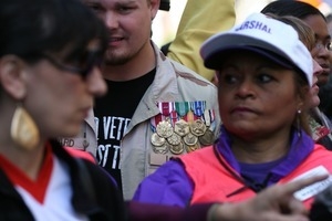 Marchers opposing the war in Iraq, including a veteran wearing service medals