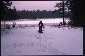 Two children playing in snow by lake