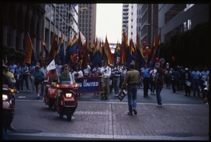 Marchers in the San Francisco Pride Parade with pride flags and banner 'Proud / Strong United 1987'