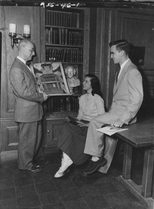 Frank Rand showing two students a picture
