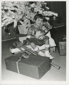 Young girl with toy under Christmas tree