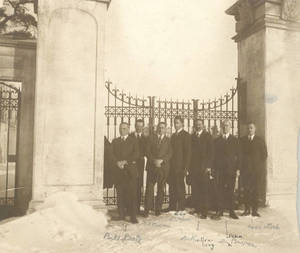 Group of men standing in front of gateway to Pratt Field