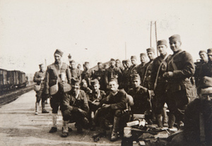 Group of soldiers posing for photo on a railroad platform