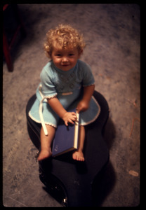 Toddler seated on a guitar case