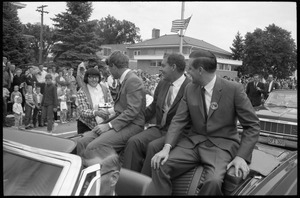 Robert F. Kennedy shaking hands with an admirer while riding in a convertible down the streets of Worthington during the Turkey Day festivities