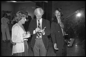Andy Warhol mingling at a reception at the Birmingham Museum of Art, another photographer at right