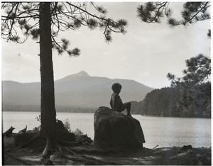 Boy, seated on a rock at Lake Chocorua