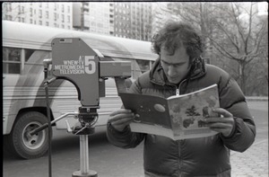 Richard Safft reading copy of Free Spirit Press magazine during interview by Channel 5 news