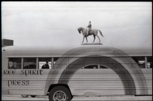 Free Spirit Press bus driving past an equestrian statue