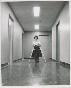 Unidentified woman with cerebral palsy walking on crutches