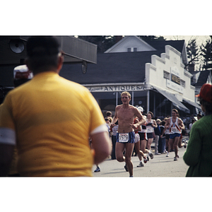 Man in yellow shirt watching runners at Boston Athletic Association (BAA) marathon