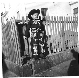 Antonio Leite Loureiro in front of fence, dressed as a cowboy