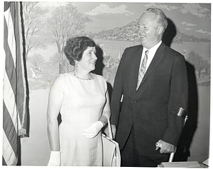 Mayor John F. Collins (right) standing with an unidentified woman in his office.