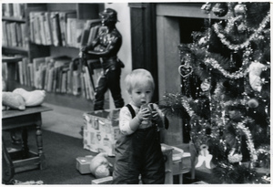 Kid and Christmas tree in the kids room at the Jones Library