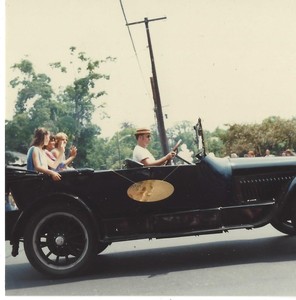 Unknown people riding a in classic black car in the Town of Plainville 75th Anniversary Diamond Jubilee parade