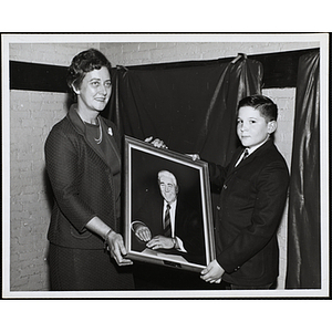 A woman and a boy holding a portrait of Nate Hurwitz, former Charlestown Boys' Club director