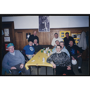 A group of men sit at a table during a Bunker Hillbilly alumni reunion event