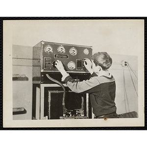 A boy tests a battery using an industrial battery tester