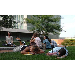 Torch Scholars relax on some grass during a scavenger hunt