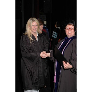 Faculty member presents student with certificate at School of Nursing convocation