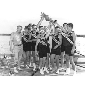 The Northeastern crew team celebrates a win holding up their trophy