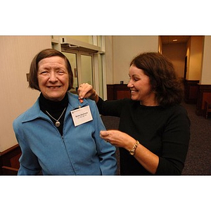 Alumna Britta Karlsson is pinned by another participant at the Alumni Legacy Breakfast