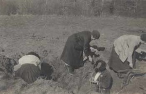 Women searching a bomb crater for souvenirs in France