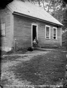 Unidentified woman and child in doorway of house
