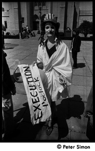 Woman in Uncle Sam hat and face paint holding sign for mock execution in front of Marsh Chapel, Boston University