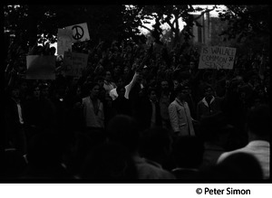 Anti-Wallace protesters at the George Wallace rally on Boston Common flashing peace signs, carrying signs with a peace symbol and 'Is Wallace common sense?'