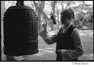Woman ringing a large Buddhist temple bell