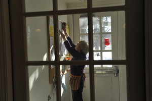 Librarian hanging a poster in the entry foyer, New Salem Public Library