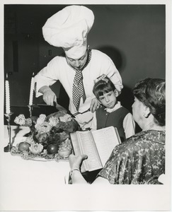 Chef carving turkey for young client