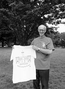 Congressman John W. Olver holding up t-shirt with the Old Central Fire House, Pittsfield, Mass., 'Rediscovering our downtown'